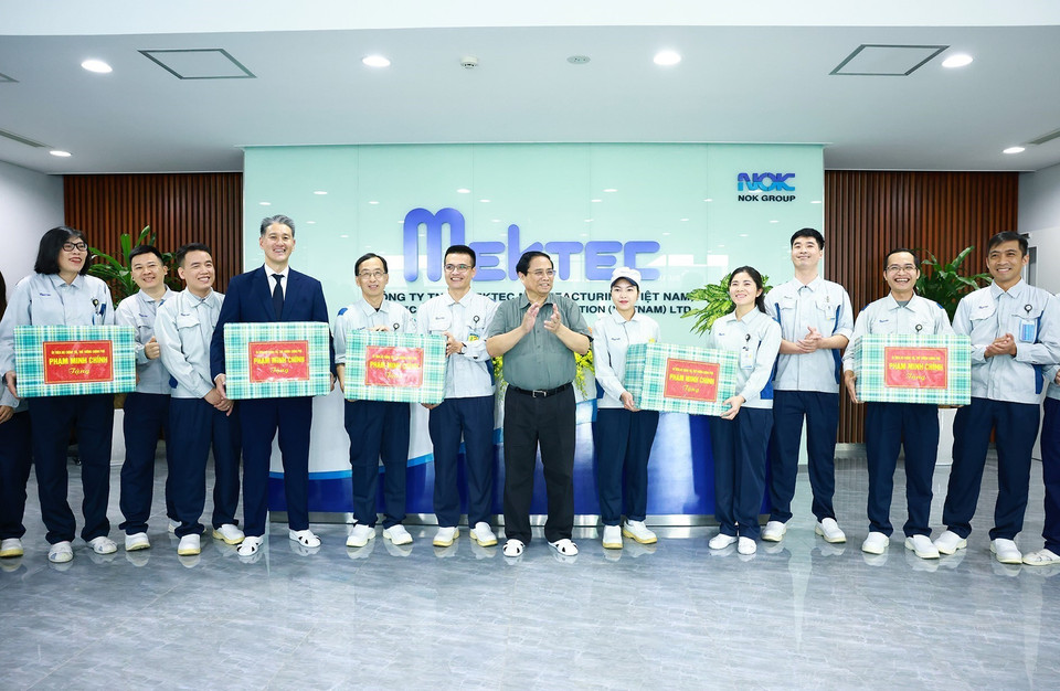 Thủ tướng Phạm Minh Chính tặng quà động viên công nhân của Công ty TNHH Mektec Manufacturing chuyên sản xuất bản mạch. (Ảnh: Dương Giang/TTXVN)