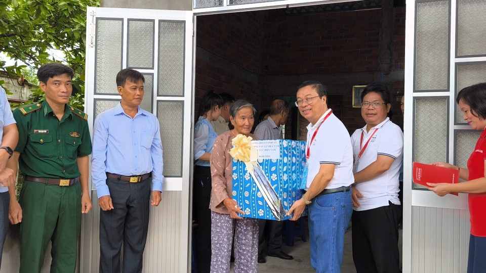 Thăm tặng quà cho người dân được nhận nhà mới. (Ảnh: Huỳnh Phúc Hậu/TTXVN)
