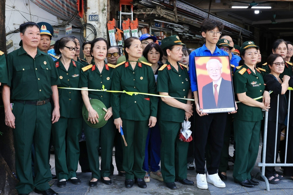 Người dân tập trung hai bên đường đưa tiễn linh cữu Tổng Bí thư Nguyễn Phú Trọng. (Ảnh: TTXVN)