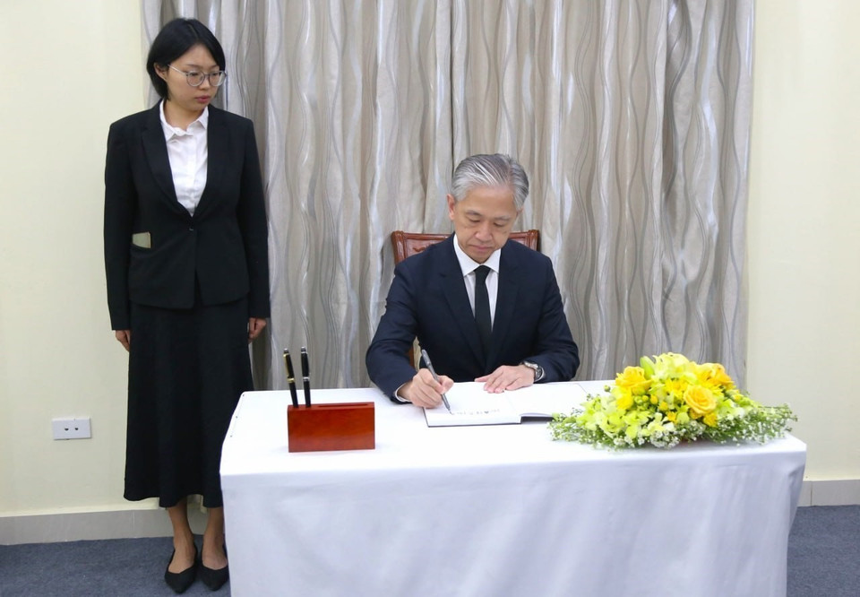 Đại sứ Trung Quốc tại Campuchia Uông Văn Bân ghi sổ tang. (Ảnh: TTXVN phát)