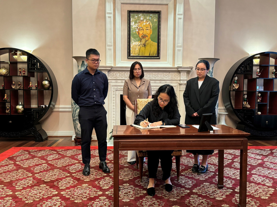 Chị Khương Hà, Bí thư Chi bộ lưu Học sinh tại Washington D.C ghi sổ tang. (Ảnh: Kiều Trang/TTXVN)