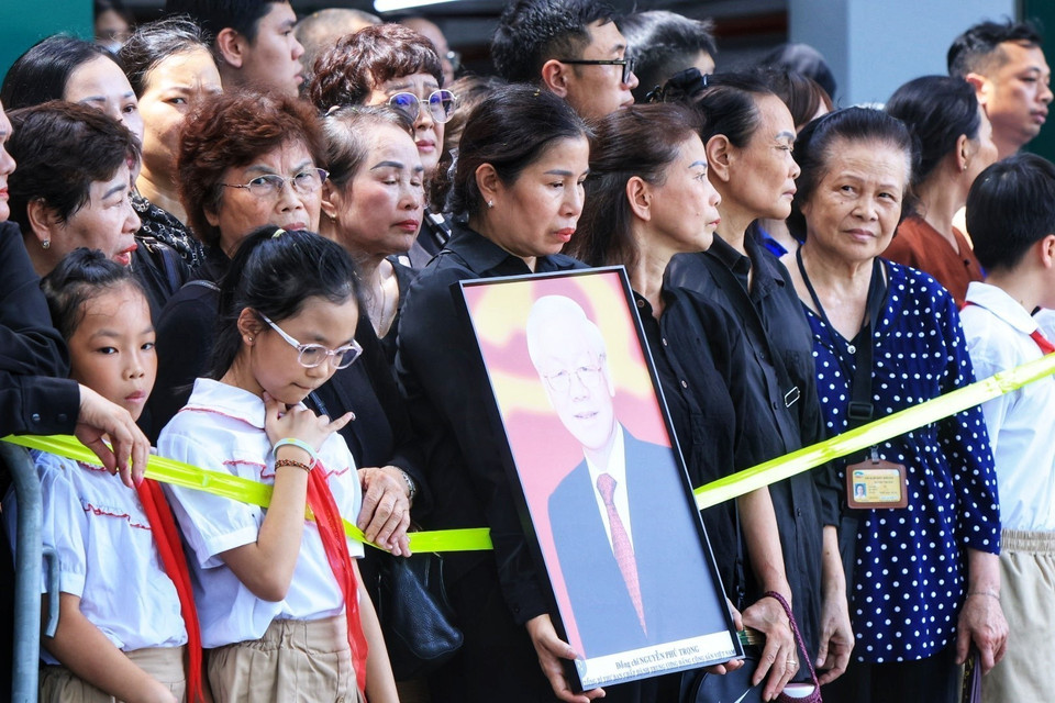 Người dân tập trung hai bên đường đưa tiễn linh cữu Tổng Bí thư Nguyễn Phú Trọng. (Ảnh: TTXVN)