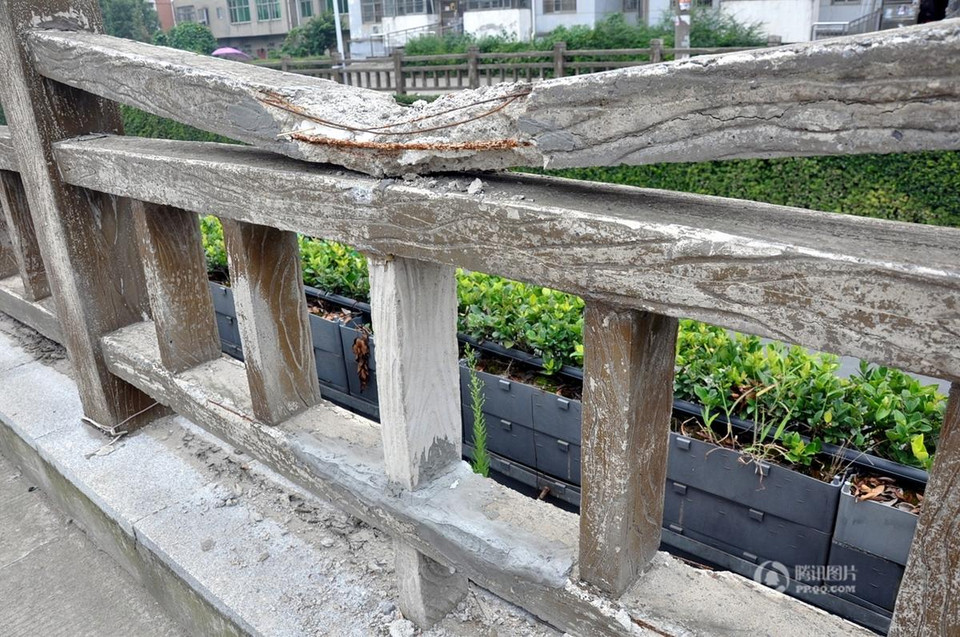 Hàng rào ximăng này được xây dựng năm 2012, phía ngoài được làm giả gỗ. Hiện nay, hàng rào đã bị hư hỏng nặng và sự thật được phơi bày: bên ngoài là ximăng, bên trong là xốp. (Nguồn: QQ)