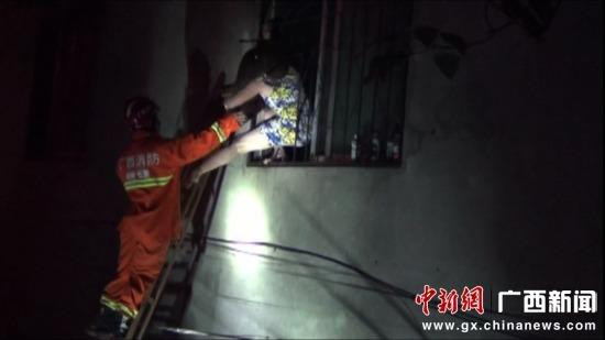 Một người phụ nữ mắc kẹt trong tòa nhà bên cạnh được cứu ra ngoài. (Nguồn: chinanews.com)