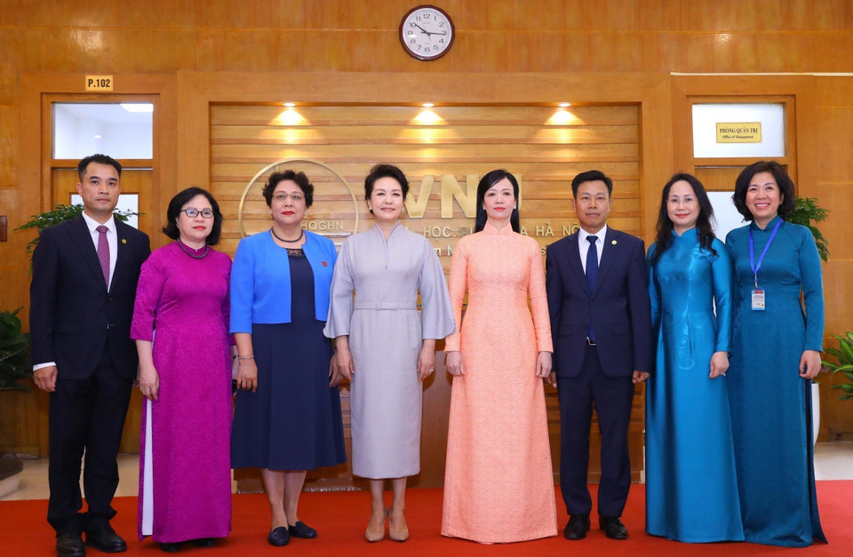 Bà Phan Thị Thanh Tâm, Phu nhân Chủ tịch nước Võ Văn Thưởng và bà Bành Lệ Viên, Phu nhân Tổng Bí thư, Chủ tịch nước Trung Quốc chụp ảnh chung với Ban lãnh đạo Đại học Quốc gia Hà Nội. (Ảnh: Văn Điệp/TTXVN)