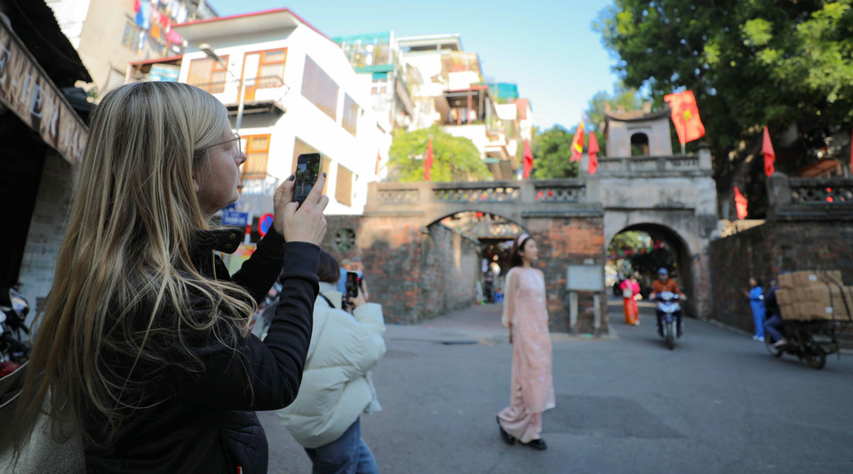 Du khách quốc tế lưu lại kiến trúc đẹp, cổ kính của Ô Quan Chưởng, Hà Nội. (Ảnh: Thanh Tùng/TTXVN)