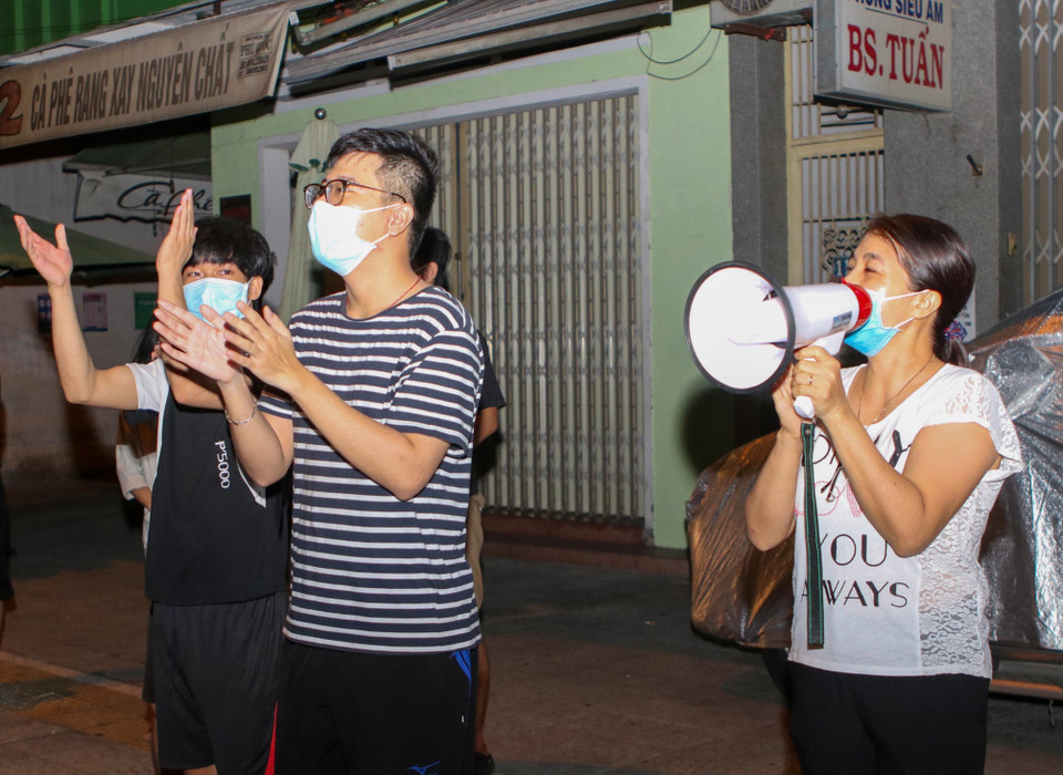Người dân trên tuyến đường Quang Trung vui mừng khi hoàn thành thời gian cách ly và khu dân cư được gỡ lệnh phong tỏa. (Ảnh: Trần Lê Lâm/TTXVN)