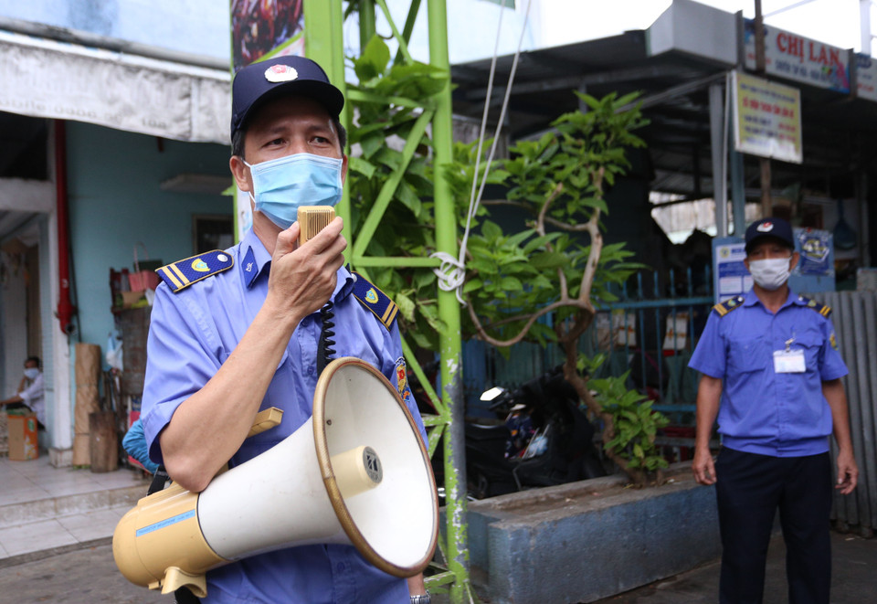 Ban quản lý các chợ có trách nhiệm kiểm tra, hướng dẫn bà con sử dụng Thẻ vào chợ. (Ảnh: Quốc Dũng/TTXVN)