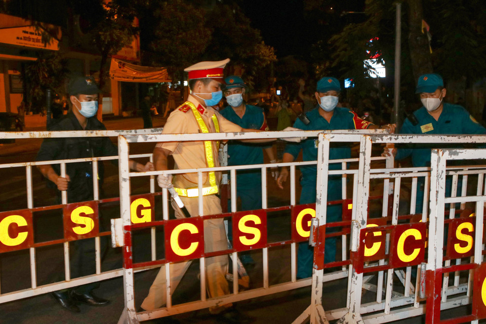 Lực lượng trực chốt thu dọn các rào chắn trên các tuyến đường sau khi được thông báo gỡ lệnh phong tỏa. (Ảnh: Trần Lê Lâm/TTXVN)