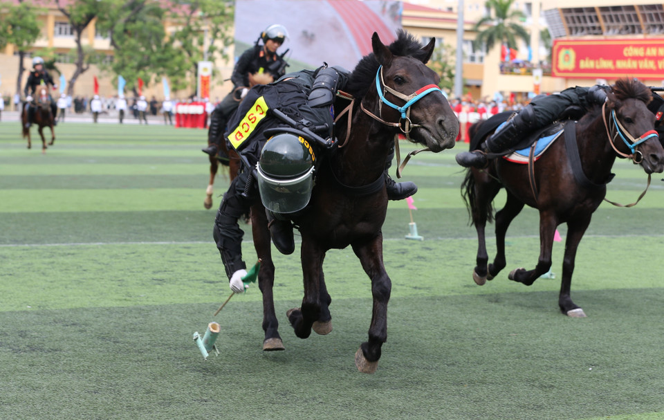 Khối Cảnh sát Cơ động Kỵ binh biểu diễn đổ nhào nhặt đồ vật, công cụ hỗ trợ. (Ảnh: Dương Giang/TTXVN)