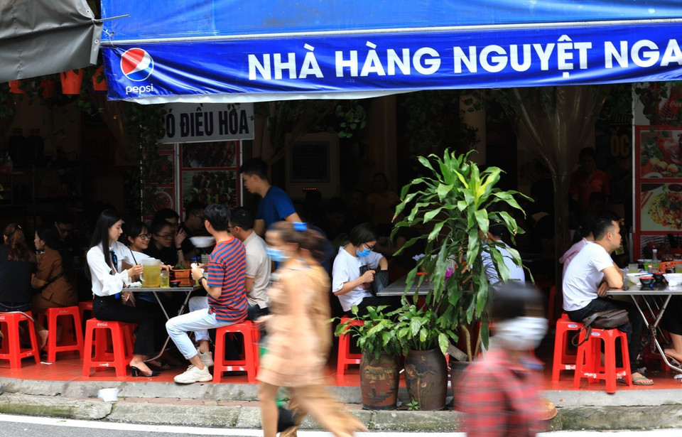 Một số hàng quán ngay trước cửa Phủ Tây Hồ vẫn không thực hiện giãn khoảng cách đúng quy định. (Ảnh: Thành Đạt/TTXVN)