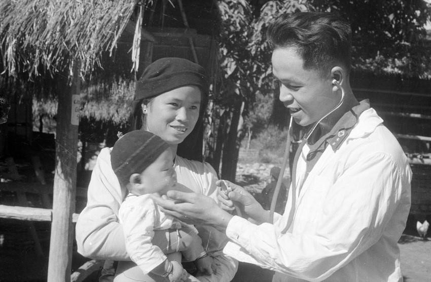 Chiến sỹ Đồn công an vũ trang Lai Châu khám bệnh cho trẻ em ở xã Chà Nưa, Mường Lay (3/1974). (Ảnh: Nguyễn Chính/ TTXVN)