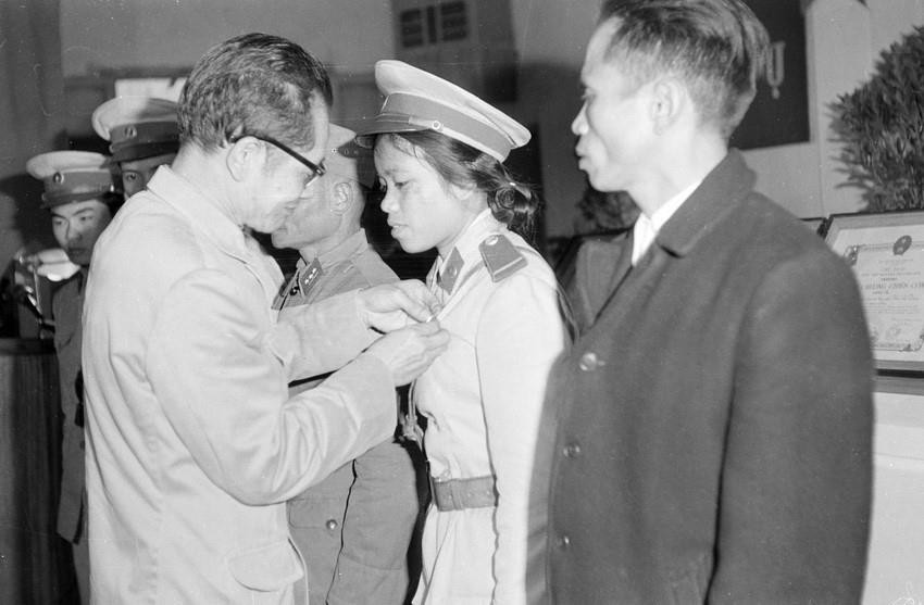 Chủ tịch Ủy ban hành chính Hà Nội Trần Duy Hưng gắn hủy hiệu Hồ Chủ tịch cho Hạ sỹ Nguyễn Thị Khuyến, công an đồn 44 có thành tích phục vụ chiến thắng đợt tập kích không quân chiến lược của giặc Mỹ vào thủ đô (1972). (Ảnh: TTXVN)