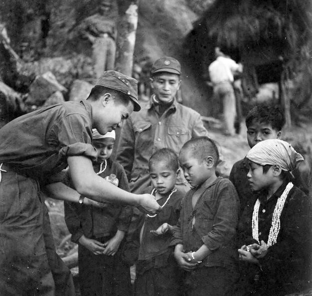 Chiến sỹ công an đồn 235 phát thuốc cho trẻ em đồng bào dân tộc (1968). (Ảnh: Vũ Tạo/TTXVN)
