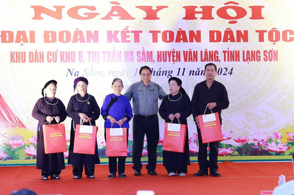 Thủ tướng Phạm Minh Chính tặng quà cho các gia đình chính sách thị trấn Na Sầm. (Ảnh: Dương Giang/TTXVN)