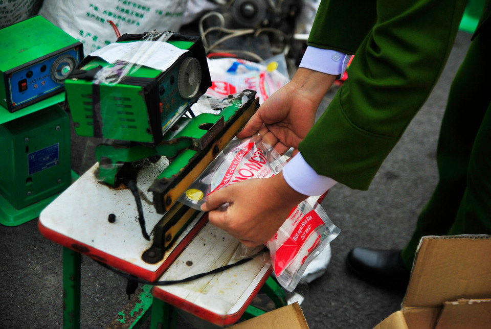Được bỏ vào bao bì đối tượng thu mua, sau đó cho lên máy hàn nhiệt. (Ảnh: Võ Phương/Vietnam+)
