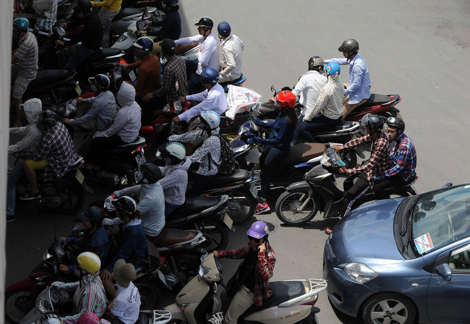 Tranh thủ ẩn mình trong bóng mát của những hàng cây trên phố. (Ảnh: Quang Quyết/TTXVN)