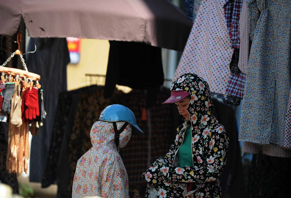 Các cửa hàng áo chống nắng lại hút khách trong những ngày nắng nóng. (Ảnh: Quang Quyết/TTXVN)