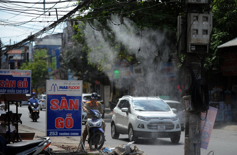 Máy phun hơi nước được lắp đặt tại nhiều cửa hàng nhằm giảm bớt không khí bớt oi bức, ngột ngạt. (Ảnh: Quang Quyết/TTXVN)