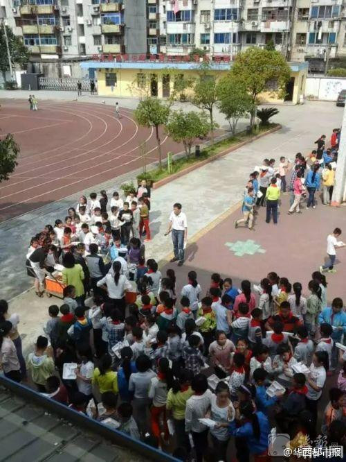 Phía nhà trường đã xác nhận do sự hạn chế về diện tích nên ngôi trường này không có nhà ăn. Họ kết hợp với một công ty đồ ăn nhanh để cung cấp bữa trưa cho học sinh. Hình ảnh học sinh đang xếp hàng nhận cơm trên sân trường. (Nguồn: QQ)