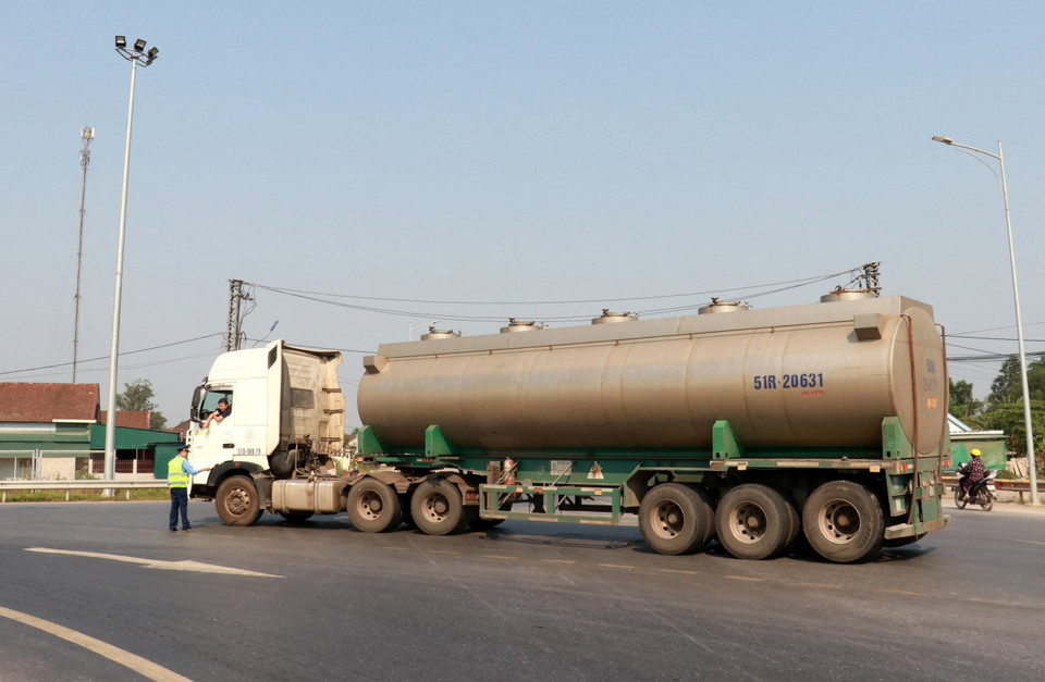 Lực lượng chức năng hướng dẫn một xe bị cấm đi vào cao tốc Cam Lộ-La Sơn đi theo hướng khác tại điểm đầu ở xã Cam Hiếu, huyện Cam Lộ (Quảng Trị). (Ảnh: Nguyên Lý/TTXVN)