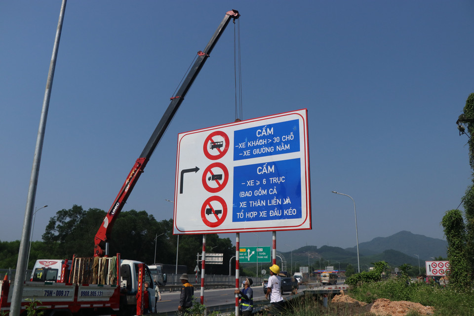 Tổ chức cắm biển báo tại lối vào cao tốc Cam Lộ - La Sơn ở nút giao cầu Tuần. (Ảnh: Nguyên Lý/TTXVN)