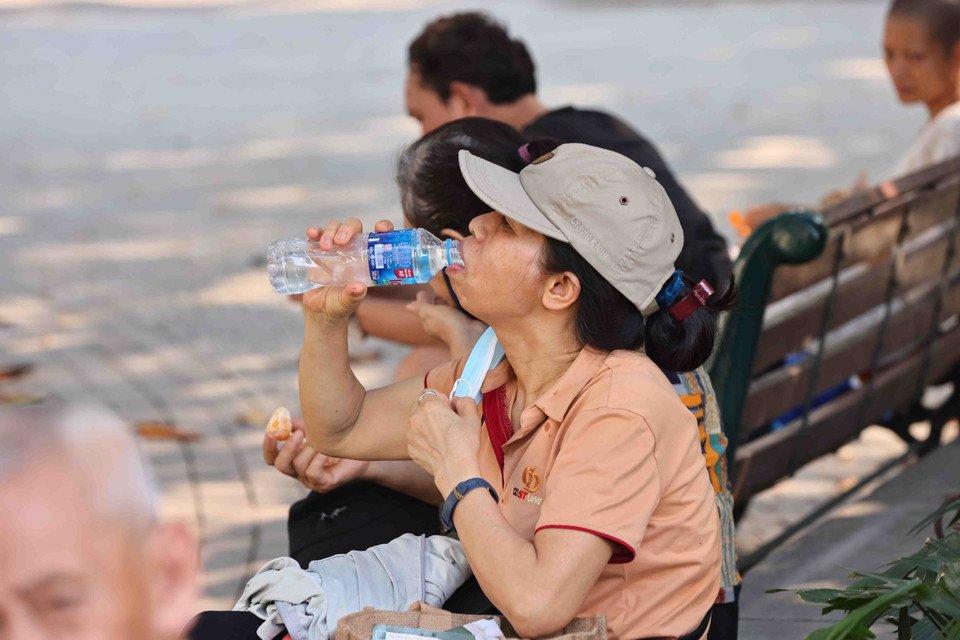 Ra đường những lúc nắng nóng, người dân đều không quên mang theo nước uống. (Ảnh: Minh Đức/TTXVN)