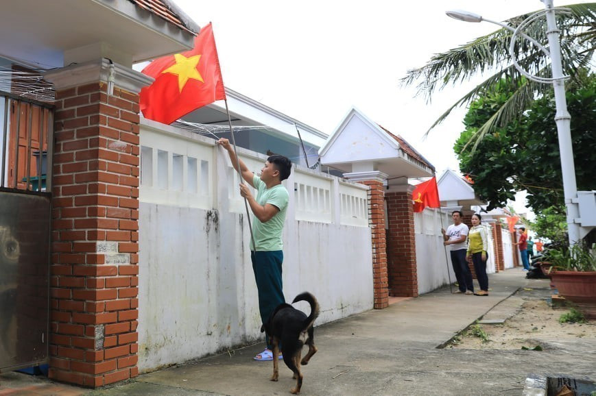 Các hộ dân trên đảo Sinh Tồn treo cờ Tổ quốc chào mừng Đại hội Đảng XIII. (Ảnh: Thành Đạt/TTXVN)