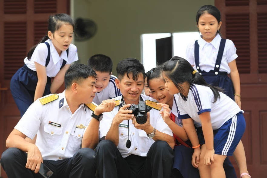 Tình quân dân giữa cán bộ Vùng 4 Hải quân cùng các em học sinh trên đảo Sinh Tồn. (Ảnh: Thành Đạt/TTXVN)