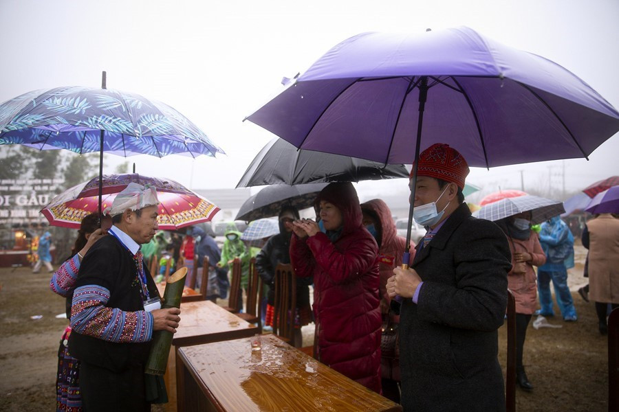 Thầy cúng mời du khách và các đại biểu tham dự lễ hội thưởng thức chút rượu trong ống nứa. (Ảnh: Trọng Đạt/TTXVN)