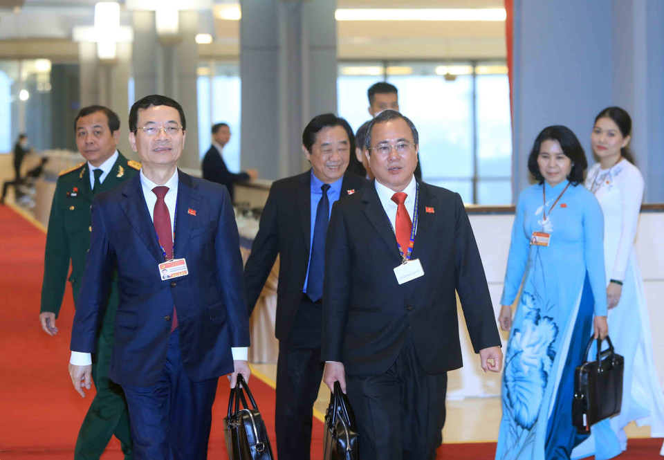 Ủy viên Trung ương Đảng, Bộ trưởng Bộ Thông tin và Truyền thông Nguyễn Mạnh Hùng (bên trái) và các đại biểu đến dự Đại hội, sáng 28/1. (Nguồn: TTXVN)