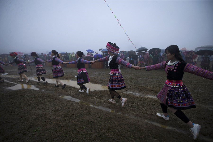 Các chàng trai, cô gái Mông cùng du khách nắm tay nhau nhảy múa theo tiếng khèn xung quanh cây nêu mặc cho trời mưa và gió lạnh. (Ảnh: Trọng Đạt/TTXVN)