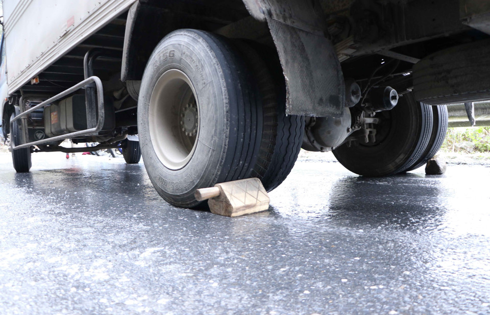 Các chủ xe phải chèn bánh để chống trượt. (Ảnh: Nguyễn Oanh/TTXVN)