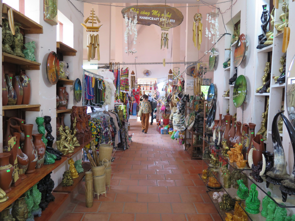 Bên trong khu nhà trưng bày sách, tranh, ảnh, vật dụng truyền thống và các món quà lưu niệm văn hóa Chăm phục vụ du khách dưới chân ngọn đầu Trầu. (Ảnh: Minh Hưng/TTXVN)