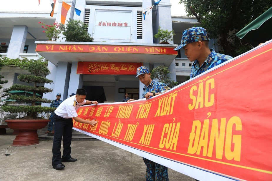 Quân, dân đảo Sinh Tồn treo khẩu hiệu thi đua chào mừng Đại hội Đảng lần thứ XIII. (Ảnh: Thành Đạt/TTXVN)