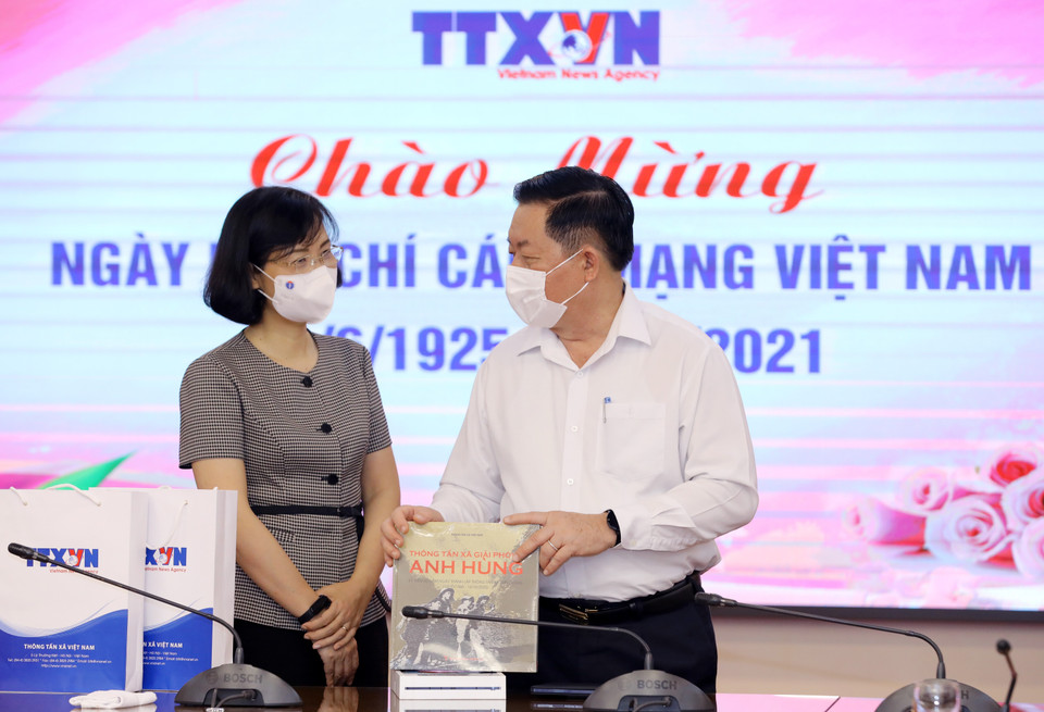 Phó Tổng giám đốc TTXVN Vũ Việt Trang tặng sách của TTXVN cho Trưởng Ban Tuyên giáo Trung ương Nguyễn Trọng Nghĩa. (Ảnh: Nguyễn Điệp/TTXVN)