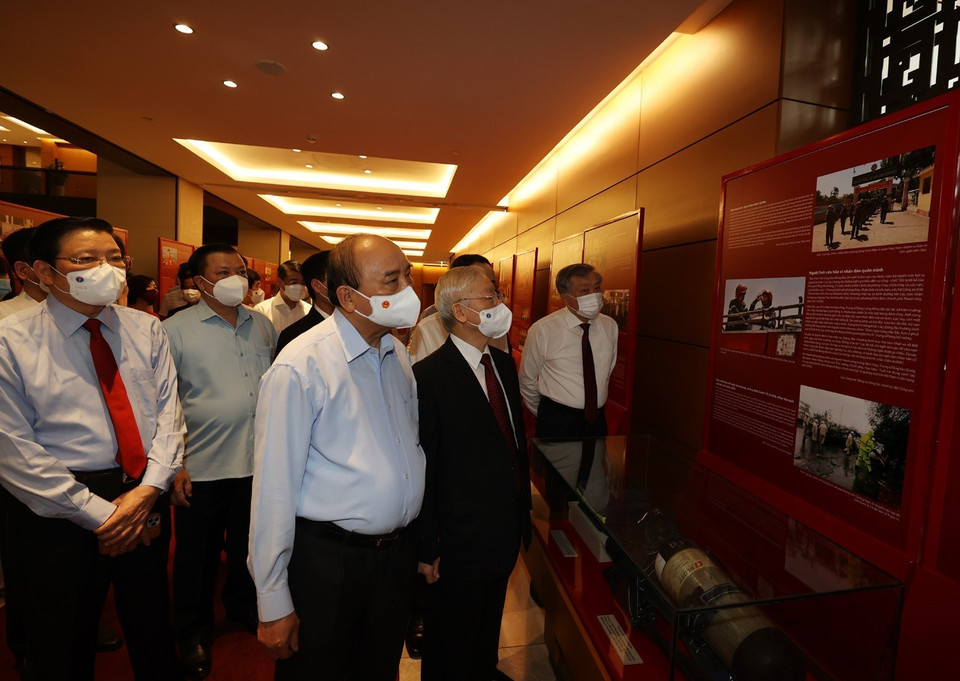 Tổng Bí thư Nguyễn Phú Trọng, Chủ tịch nước Nguyễn Xuân Phúc, Thường trực Ban Bí thư Võ Văn Thưởng và các đại biểu thăm Triển lãm Những tấm gương bình dị mà cao quý trưng bày bên sảnh hội nghị. (Ảnh: Trí Dũng/TTXVN)