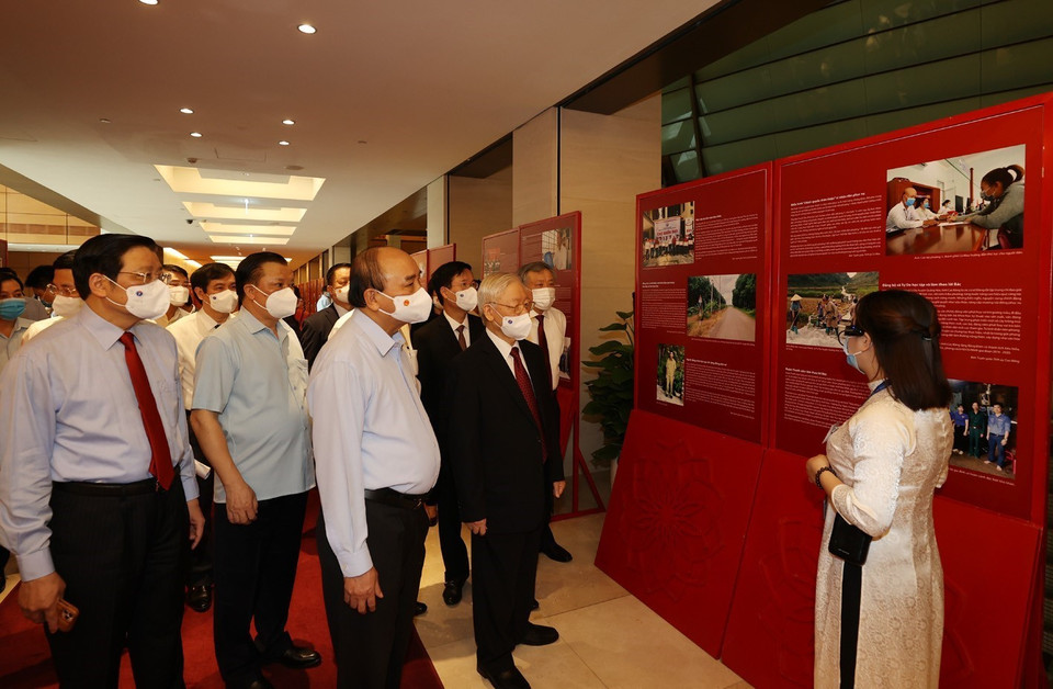 Tổng Bí thư Nguyễn Phú Trọng, Chủ tịch nước Nguyễn Xuân Phúc, Thường trực Ban Bí thư Võ Văn Thưởng và các đại biểu thăm Triển lãm Những tấm gương bình dị mà cao quý trưng bày bên sảnh hội nghị. (Ảnh: Trí Dũng/TTXVN)