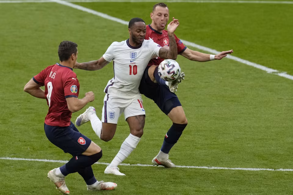 Tiền đạo Raheem Sterling của đội tuyển Anh nỗ lực đi bóng trong sự đeo bám quyết liệt của hậu về đội tuyển Cộng hòa Séc trong trận đấu ở lượt đấu cuối bảng D. (Ảnh: AFP/TTXVN)