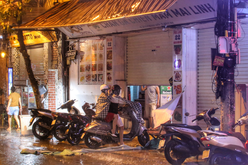 Một vài phương tiện phải trú tạm vào vỉa hè do gió mạnh. (Ảnh: Tuấn Đức/TTXVN)