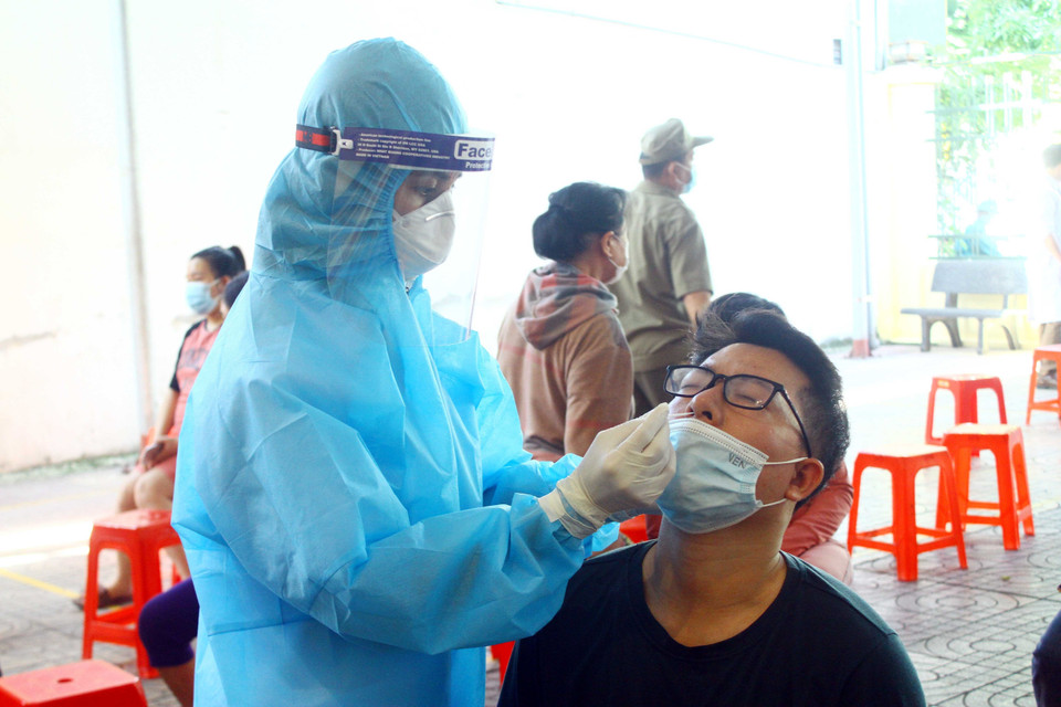 Cán bộ y tế lấy mẫu xét nghiệm cho người dân khối 5, phường Hà Huy Tập. (Ảnh: Tá Chuyên/TTXVN)