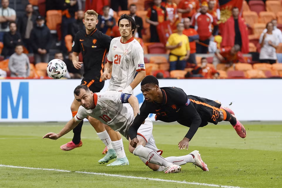 Pha tranh bóng quyết liệt giữa tiền đạo Bắc Macedonia Goran Pandev (trái) và hậu vệ Hà Lan Denzel Dumfries trong trận đấu bảng C. (Ảnh: AFP/TTXVN)