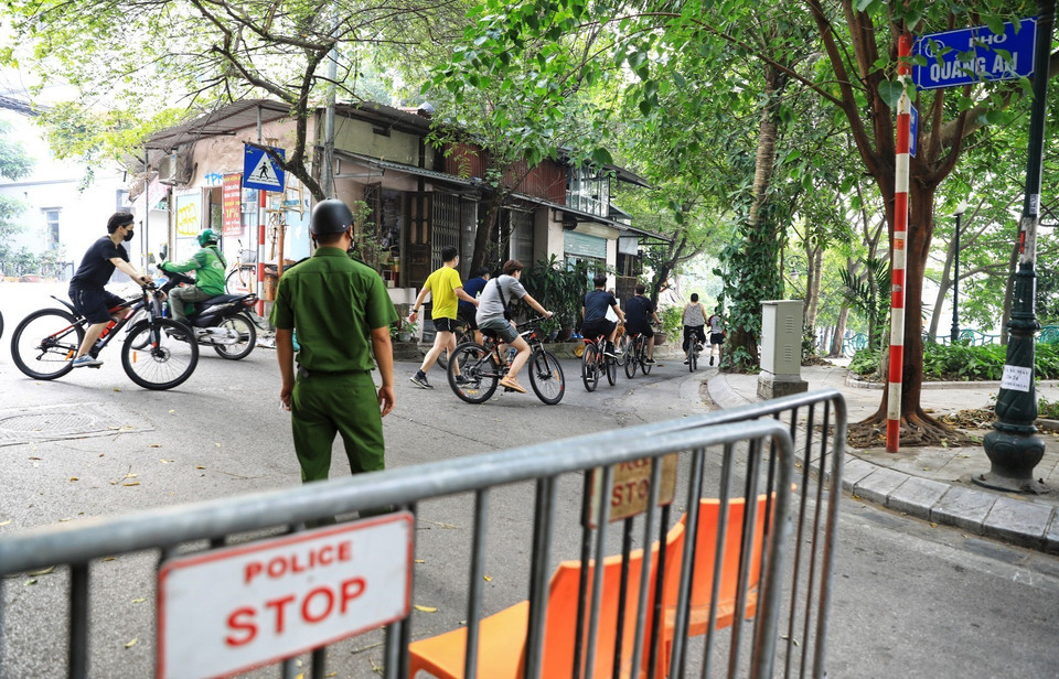 Lực lượng chức năng phường Quảng An lập chốt nhắc nhở, cấm người đi xe đạp, chạy bộ đi vào khu vực này. (Ảnh: Thành Đạt/TTXVN)