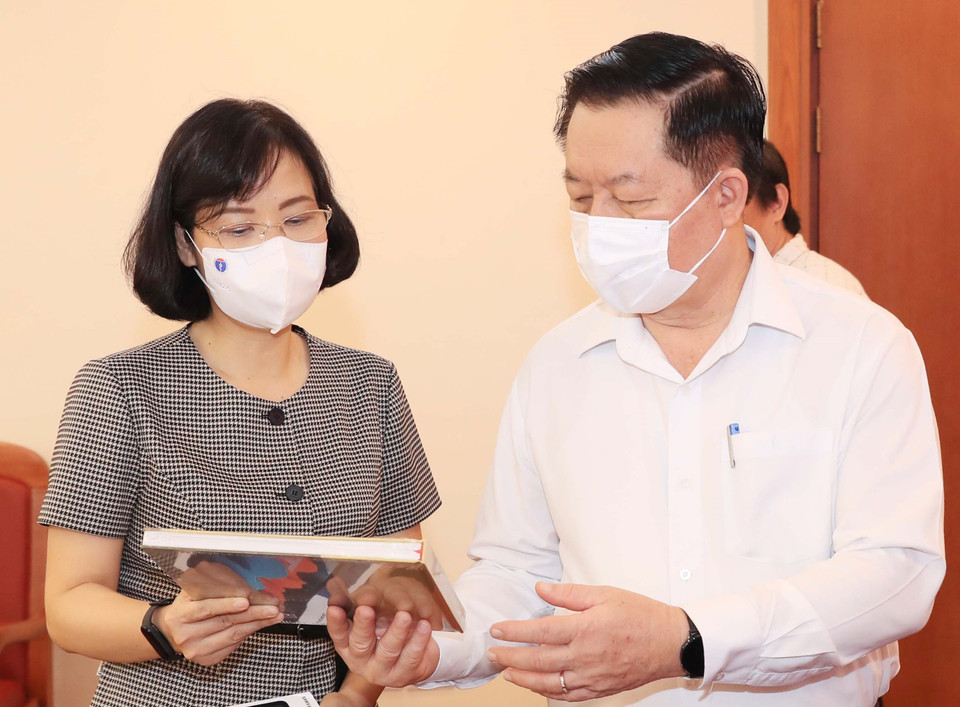 Phó Tổng Giám đốc Thông tấn xã Việt Nam Vũ Việt Trang giới thiệu các ấn phẩm của TTXVN với đồng chí Nguyễn Trọng Nghĩa. (Ảnh: Nguyễn Điệp/TTXVN)