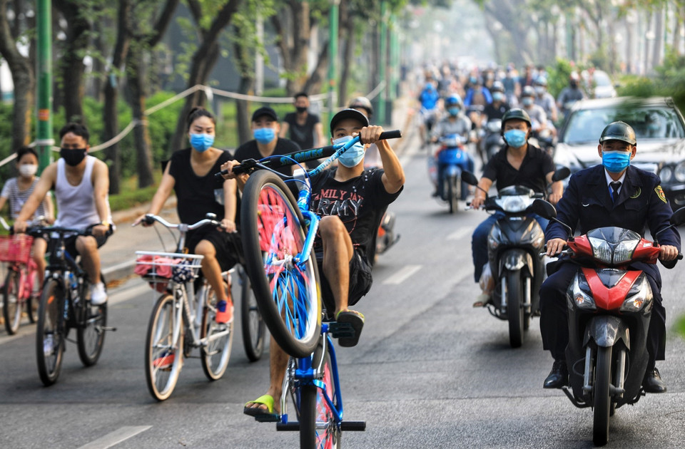 Một số em nhỏ còn biểu diễn bốc đầu xe đạp giữa dòng người đang đạp xe tại hồ Tây (Ảnh chụp lúc 7 giờ ngày 6/6/2021). (Ảnh: Thành Đạt/TTXVN)