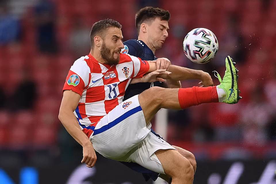 Pha tranh bóng quyết liệt giữa hậu vệ Scotland Kieran Tierney với tiền vệ Croatia Nikola Vlasic (trái) trong trận lượt cuối bảng D. (Ảnh: AFP/TTXVN)