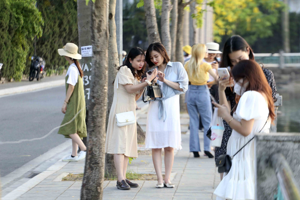 Nhiều bạn trẻ vẫn tụ tập ở ven Hồ Tây, nhiều người không đeo khẩu trang. (Ảnh: Tuấn Đức/TTXVN)