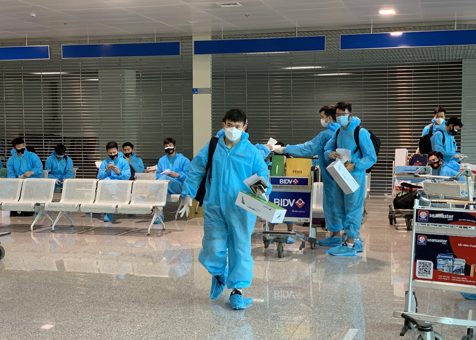 Hậu vệ Lê Văn Xuân ra xe về khách sạn để thực hiện cách ly. (Ảnh: Hoàng Linh/TTXVN)