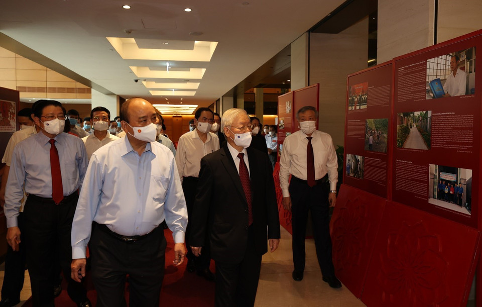Tổng Bí thư Nguyễn Phú Trọng, Chủ tịch nước Nguyễn Xuân Phúc, Thường trực Ban Bí thư Võ Văn Thưởng và các đại biểu thăm Triển lãm Những tấm gương bình dị mà cao quý trưng bày bên sảnh hội nghị. (Ảnh: Trí Dũng/TTXVN)
