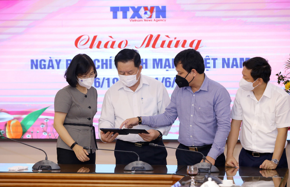 Phó Tổng Giám đốc TTXVN Vũ Việt Trang giới thiệu các ấn phẩm điện tử của TTXVN với Trưởng Ban Tuyên giáo Trung ương Nguyễn Trọng Nghĩa. (Ảnh: Nguyễn Điệp/TTXVN)